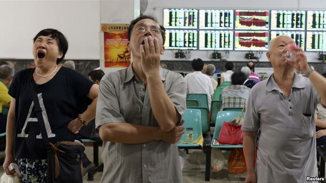 在武汉的证券交易市场，股民们看着电脑屏幕上的股市行情。