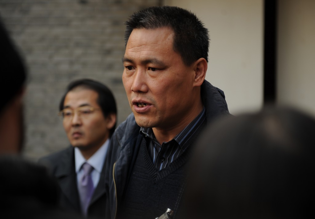 Pu Zhiqiang (C), the lawyer for Chinese artist Ai Weiwei, talks to the media at the artist's studio in Beijing on November 14, 2011.  Pu said the tax office in Beijing has refused to accept money the activist needs to pay in order to lodge an appeal against a huge tax bill.     AFP PHOTO/Peter PARKS