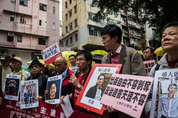 本周，抗议者手持五名失踪出版商的照片，包括李波的头像（右二）。