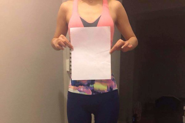 一位不愿具名的24岁中国学生举着一张纸，以显示自己的纤腰。