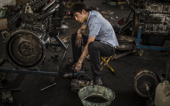 2014年6月13日，济南，16岁的詹林鑫在蓝翔技校组装柴油发动机。/视觉中国