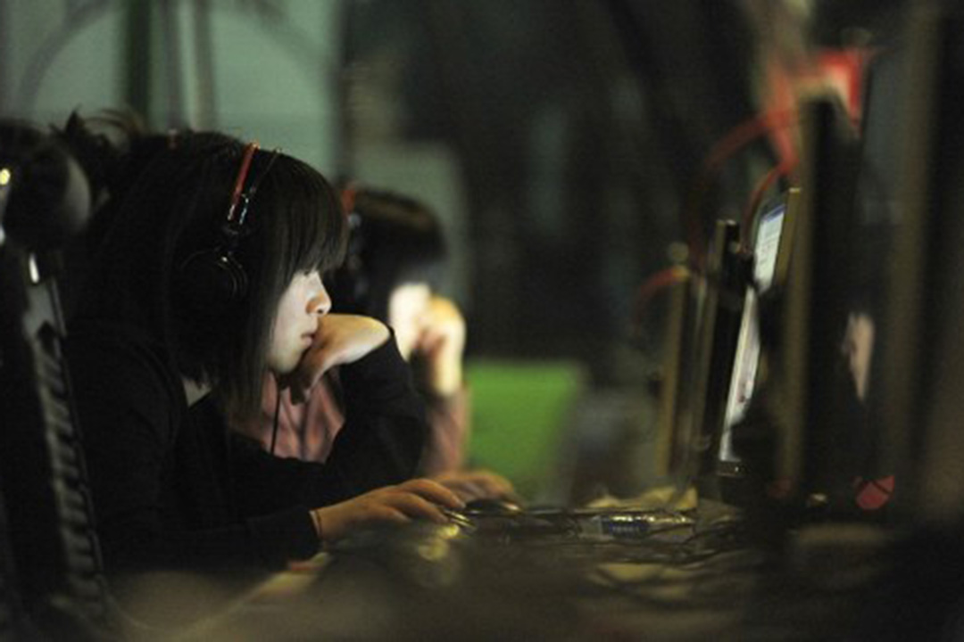 图为北京一名女子在网吧中使用电脑。摄：Gou Yige/AFP