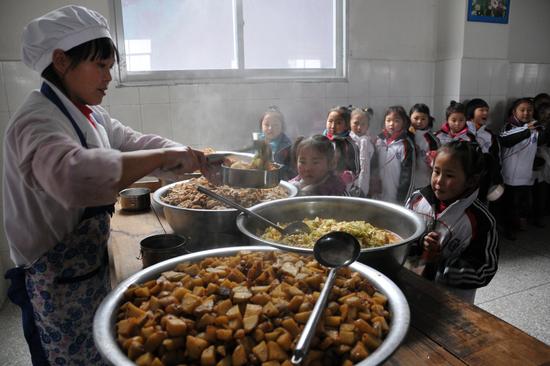 2012年12月17日，重庆巫山县，在农村学校食堂打饭的小学生。/视觉中国