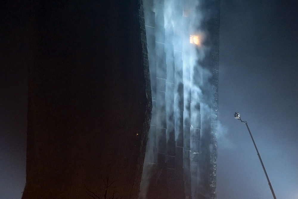 Firefighters spray the CCTV complex blaze from a giant ladder.