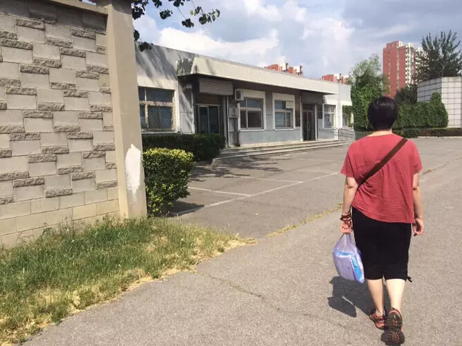 Meng Qun visits the detention center to bring clothes to her husband.