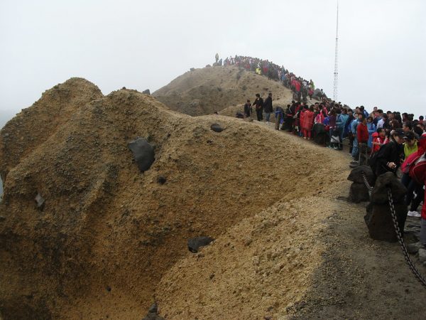Hundreds of people crowd atop a rocky summit in the Changbaishan mountain range of northeastern China.