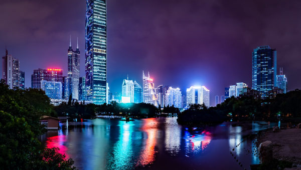 The bright lights and neon signs of Shenzhen’s forest of skyscrapers are reflected on the surface of Lihu Lake.