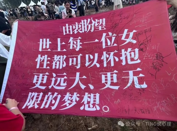 The message, printed in white text on a red flag, is also adorned with a multitude of handwritten messages.
