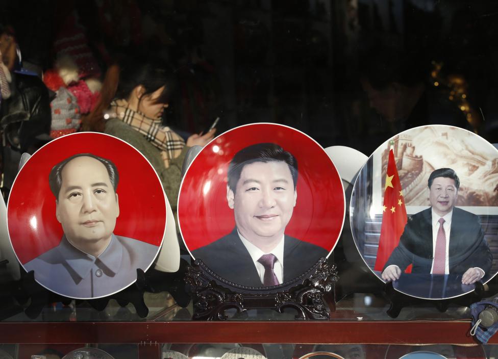 Souvenir plates bearing images of China's President Xi Jinping and China's late Chairman Mao Zedong are displayed at a shop nearby Great Hall of the People where National People's Congress will be held, in Beijing