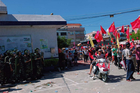 村民于村内游行，近村口处有百多名公安戒备，部份配备盾牌。摄：端传媒摄影部