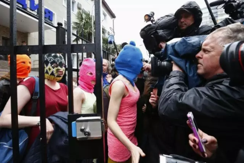 2014年2月，索契冬奥会期间，蒙着头套的“暴动小猫乐队”（译者注：女性主义朋克乐队，反普京）成员离开阿德勒警察局。