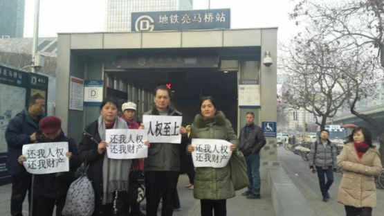 访民在地铁亮马桥站展示要求保障人权的纸牌。（志愿者提供/记者乔龙）