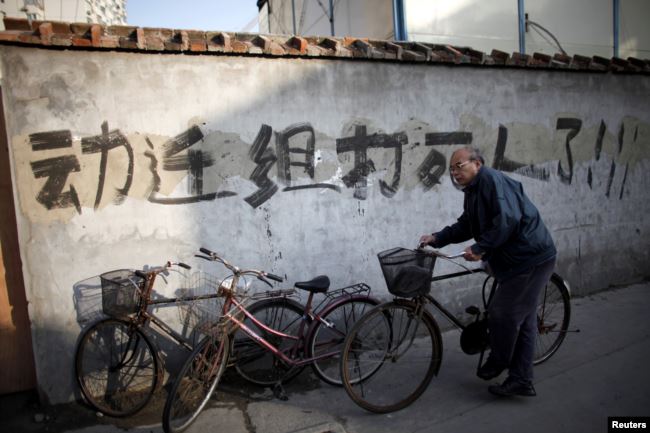 资料照：一名男子骑车走过上海街头一处拆迁地。（2010年12月1日）