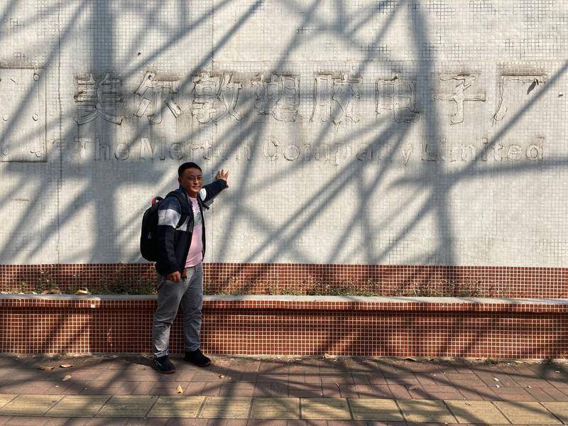 侯国安站在他曾经工作过的工厂前，这家工厂现已分拆出租，原来厂门的名字也被拆下