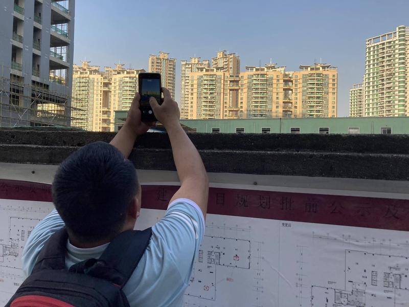 侯国安在施工工地外拍摄