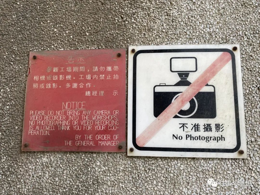 Two small Chinese and English signs warn that photography and video recording is not allowed in the factory.