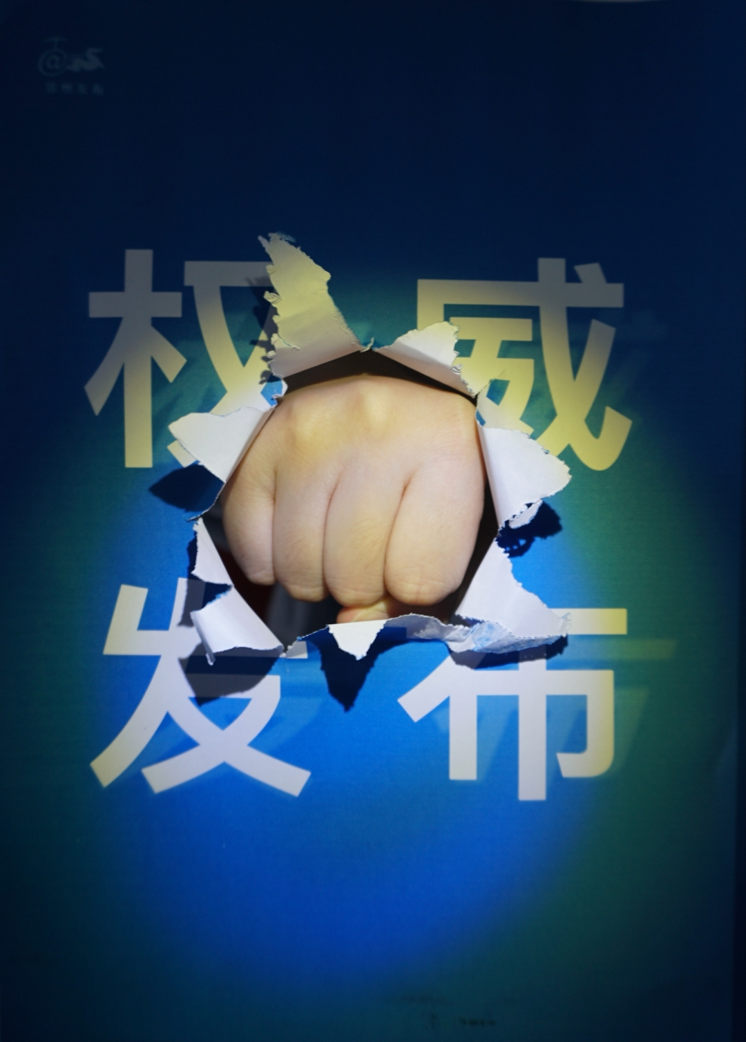 A fist punches through a blue cover with white Xinhua News font characters reading, “Official Press Release.” 