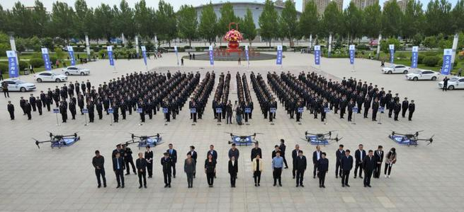 Wenguan officers standing at attention in a plaza with five large drones in the foreground