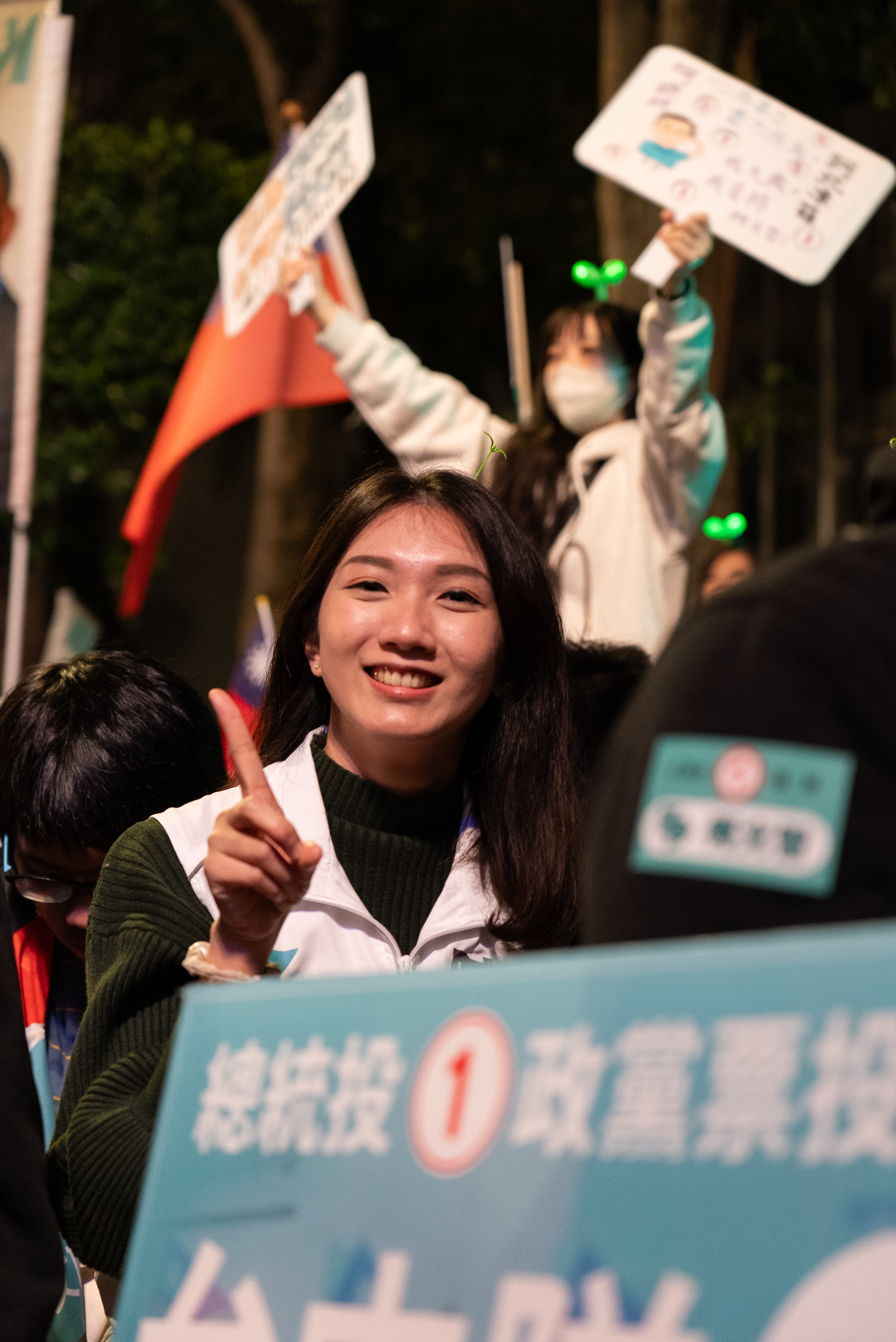 在台湾总统大选集会的现场，一位选民面对镜头面露笑容。