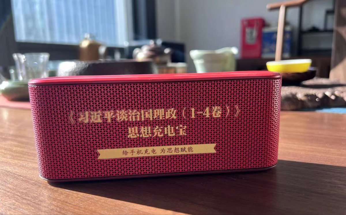 A photograph of the "ideology power bank" which is red and has yellow text.