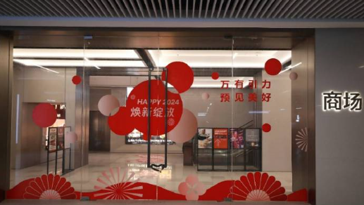 The glass doors to a shopping mall are adorned with decals of red and white circles, blooming flowers, and festive New Year's messages.