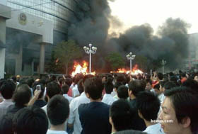 Rioters watch a public building go up in flames in Weng\'an county, Guizhou Province