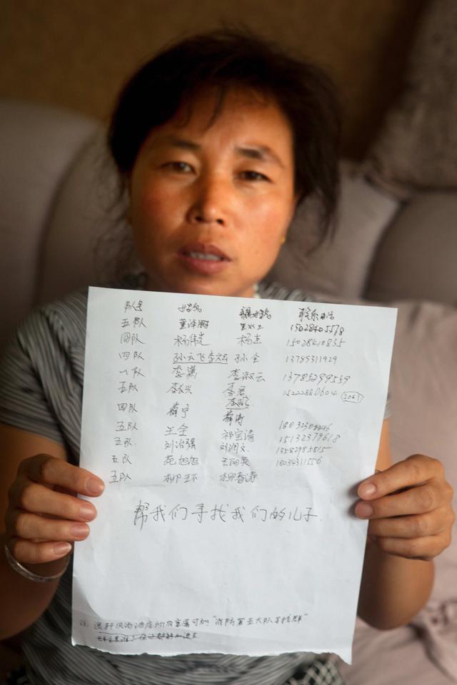 The mother of Yang Weiguang, one of the missing firefighters from Tianjin Port Company’s fourth fire brigade, wrote “Help us find our son” below a list of the names of the missing.
