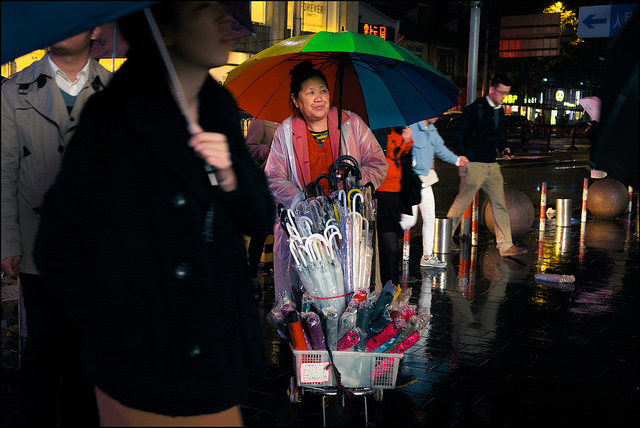 Woman selling umbrellas in rain