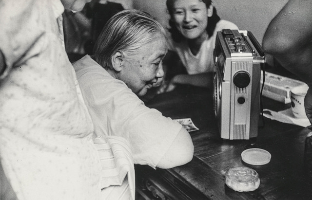 Elderly Chinese woman listening to a radio
