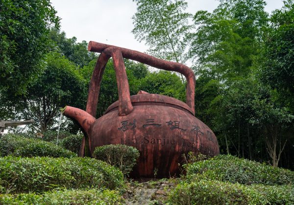 An enormous fountain - in the form of a rust-colored metal teapot decorated with Chinese characters, with water pouring from its spout - adorns the Liu Sanjie Tea Farm in Guangxi Province, China.