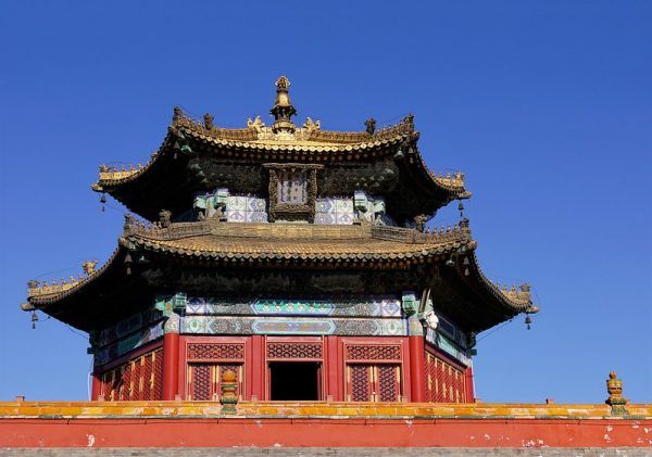 Against the clear blue sky, a six-sided vermillion pavilion with a roof of gilt copper adorns the top of CiHangPuDu Hall in Putuo Zongcheng Temple (located in Chengde, Hebei Province, China.)