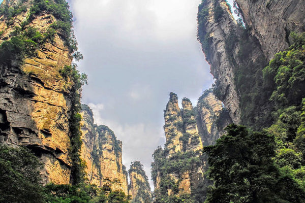 Viewed from below, these towering quartz-sandstone pillars of Zhangjiajie National Forest Park in Hunan Province, China, rise into a cloudy sky like strange monoliths.