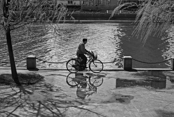 A man cycling by a lake