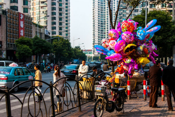 A large cluster of balloons—Doraemon, Pleasant Goat, Dora the Explorer, Spongebob Squarepants, Mickey and Minnie Mouse, the Teletubbies, pretty much anyone who's anyone—tethered to a motorcycle on a Shanghai sidewalk