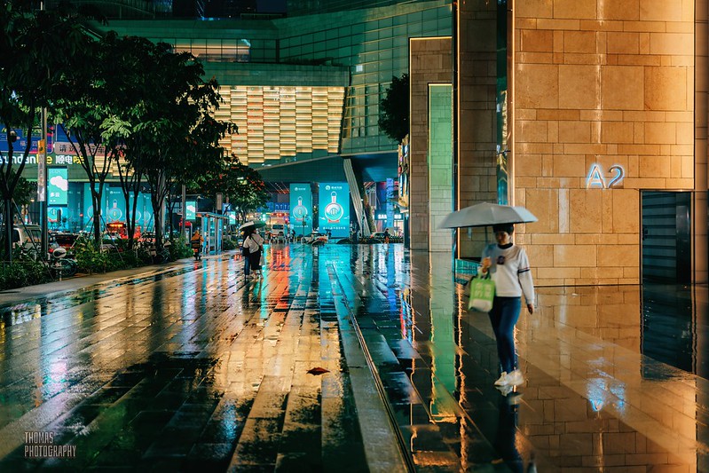 Wet sidewalk reflects city lights in Shenzhen