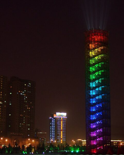 Against the night sky, each floor of the glass highrise “Full Moon Tower” at Galaxy Park in Tianjin is illuminated in a different shade of the rainbow.