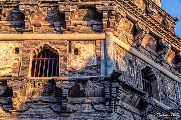 Sunlight illuminates the ornamental windows and elaborate, crumbling brickwork of the Tiger Hill Pagoda in Suzhou, often nicknamed the “Leaning Tower of China.”