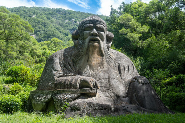 An enormous stone statue of the founder of Taoism, Lao Tze, is surrounded by the verdant trees, vegetation, and forested hills of Quanzhou's "Emporium of the World in Song-Yuan China."