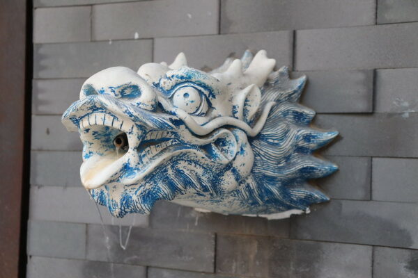 A small wall fountain in Wangfujing shopping street in Beijing features intricately designed blue and white porcelain, in the shape of a fierce dragon’s head.