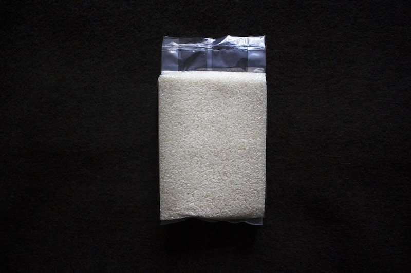 A photo of a bag of white rice against a black background.