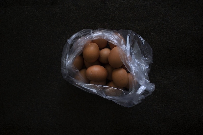 A plastic bag filled with brown eggs.